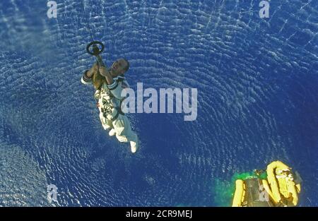 Astronauten Charles Conrad jr. ist bis zu einer Marine Helikopter hochgezogen, während Astronauten L. Gordon Cooper jr. in eine Rettungsinsel unten nach der Wasserung der Gemini-5 wartet Stockfoto