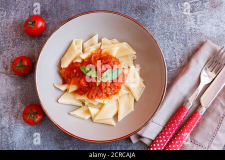 Kurze Pasta-Gericht mit Tomatensauce und Basilikum Stockfoto