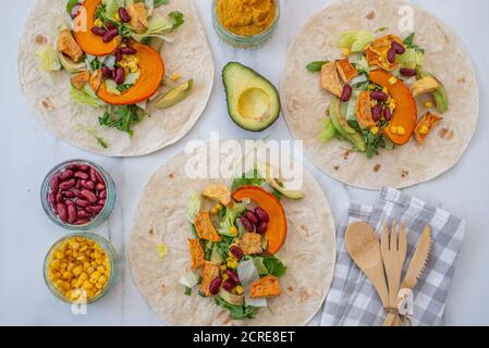 Offene vegane Tortilla Wraps mit Süßkartoffeln, Bohnen, Avocado und Kürbis Stockfoto