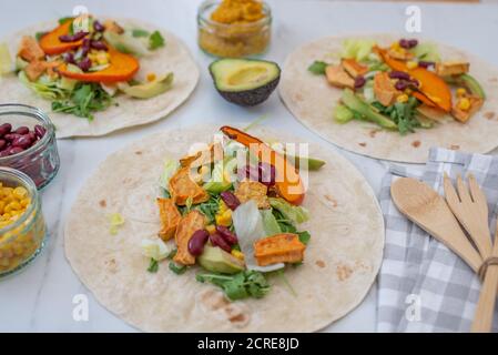 Offene vegane Tortilla Wraps mit Süßkartoffeln, Bohnen, Avocado und Kürbis Stockfoto