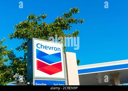 Chevron Öl-Industrie-Unternehmen Zeichen an Chevron Tankstelle gegen Baum und blauen Himmel - San Jose, Kalifornien, USA - 2020 Stockfoto