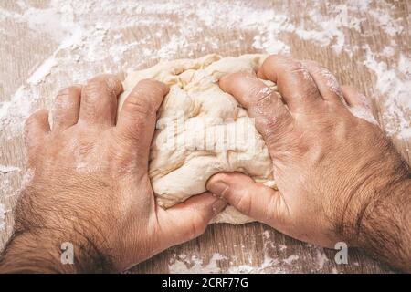 Männliche Chef knetet den Teig, Hände, Nahaufnahme Stockfoto