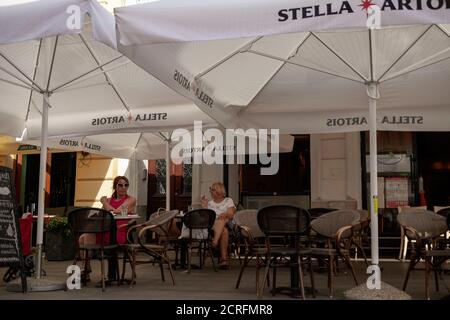 Belgrad, Serbien, 17. Sep 2020: Blick auf Straßencafé im tiefen Schatten unter Sonnenschirmen Stockfoto