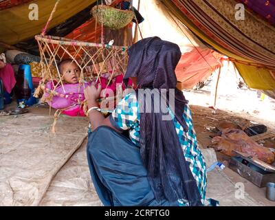 DISTRIKT KATNI, INDIEN - 29. JANUAR 2020: Ein indisches Dorf arme Mutter kümmert sich um sein neugeborenes Kind in Kinderschaukel. Stockfoto