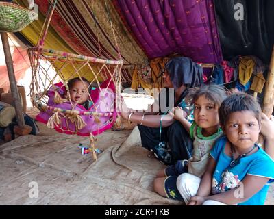 DISTRIKT KATNI, INDIEN - 29. JANUAR 2020: Eine asiatische Dorf arme Mutter Pflege sein neugeborenes Kind in Kinderschaukel. Stockfoto