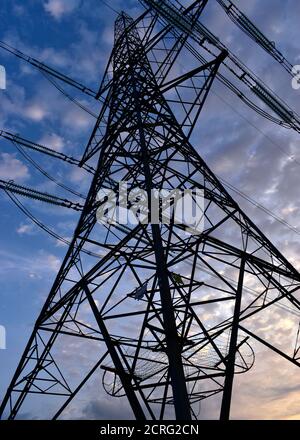 Elektrischer Pylon elektrischer Turm in Teil Silhouette von unten betrachtet Blick nach oben in der Morgendämmerung. Stockfoto