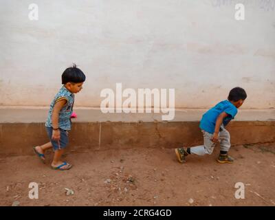 DISTRIKT KATNI, INDIEN - 21. MAI 2020: Zwei indische kleine Kinder spielen mit Spielzeugauto zusammen in offener Umgebung. Stockfoto