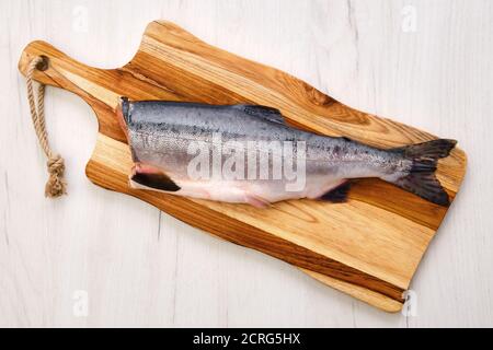 Draufsicht auf rohen frischen kopflosen rosa Lachs auf Holz Schneidebrett Stockfoto