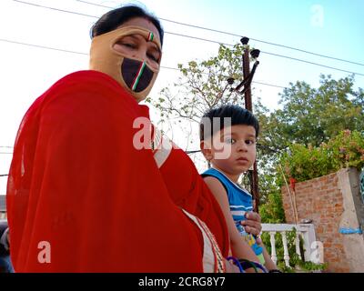 DISTRIKT KATNI, INDIEN - 21. MAI 2020: Indische kleine Kinder sitzen mit seiner Mutter in offener Umgebung. Stockfoto