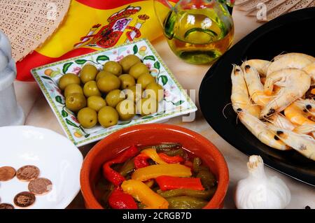 Auswahl an spanischen Tapas, darunter grüne Oliven, gemischte Paprika in Olivenöl und Garnelen, Calahonda, Spanien. Stockfoto