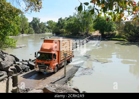 Roter LKW, der durch die gefährliche Gezeitenüberquerung des East Alligator River bei der berühmten Cahill's Crossing, Kakadu National Park, Northern Territo fährt Stockfoto