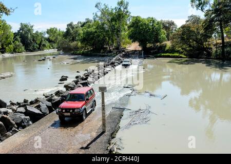 Fahrzeuge fahren durch die gefährliche Gezeitenüberquerung des East Alligator River an der berühmten Cahill's Crossing, Kakadu National Park, Northern Territor Stockfoto