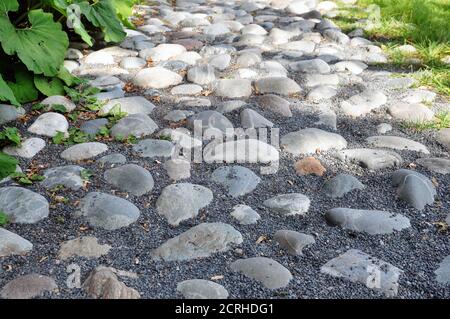Wanderweg im Park von großen Granitfelsen mit Gras bewachsen. Stockfoto