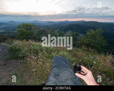 Morgendliche Tasse Tee nach dem Biwak-Schlafen auf dem Berggipfel. Früh aufwachen, ein Frühstück einnehmen und weiter auf dem Trail. Stockfoto