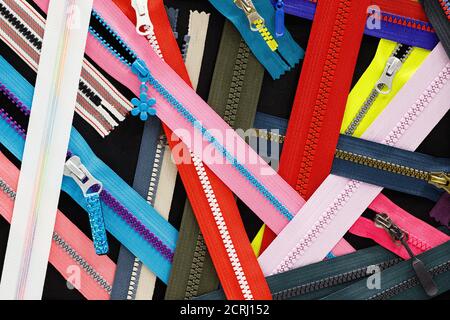 ZIP Hintergrundtextur von Reißverschlüssen Sliders. Viele Reißverschlüsse in verschiedenen Farben. Nähen Kleidung, Atelier, Stoff und Zubehör Shop. Hobby diy Conce Stockfoto