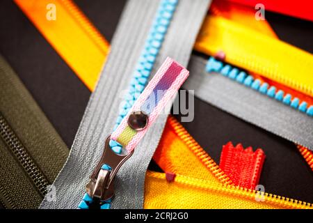 ZIP Hintergrundtextur von Reißverschlüssen Sliders. Viele Reißverschlüsse in verschiedenen Farben. Nähen Kleidung, Atelier, Stoff und Zubehör Shop. Hobby diy Conce Stockfoto