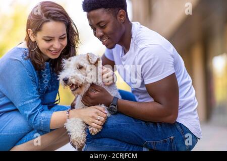 Glückliches junges Paar mit ihrem Haustier Hund im Freien Stockfoto