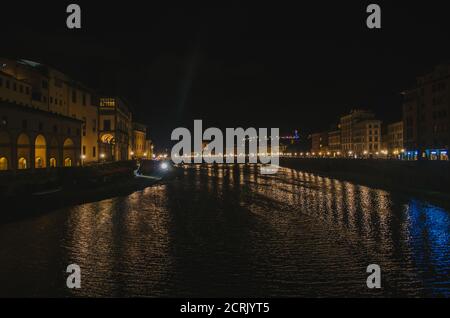 Rom, Italien - EIN Panoramablick auf Ponte Vecchio und den Arno, der die Gebäude in seinem Wasser reflektiert, während eines beleuchteten und romantischen Abends. Stockfoto