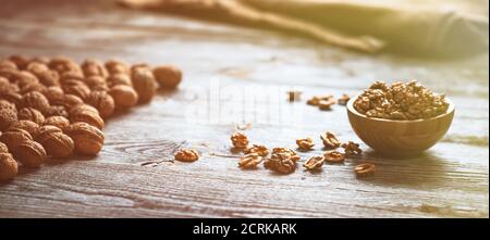 Frische Walnusskerne und ganze Walnüsse in einer Schüssel auf rustikalem alten Holztisch. Gesunde Bio-Lebensmittel, Bio-Weingärten, natürlichen Hintergrund. Speicherplatz für Ihren kopieren Stockfoto