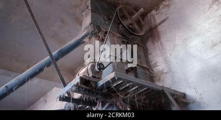 Eine alte rostige Reismühle Maschinenwerkzeugband ausgesetzt, um den staubigen Hintergrund. Stockfoto