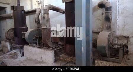 Eine alte rostige Reismühle Maschinen liefern Werkzeug ausgesetzt, um den staubigen Hintergrund. Stockfoto