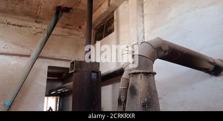 Eine alte rostige Reismühle Maschinenwerkzeug ausgesetzt, um den staubigen Hintergrund. Stockfoto