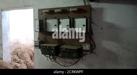 Ein alter, rostiger Transformator der Reismühle ist dem staubigen Hintergrund ausgesetzt. Stockfoto