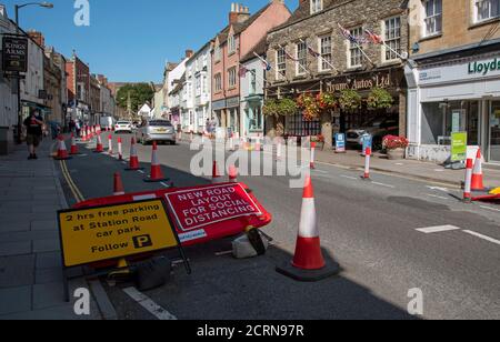 Malmesbury, Wiltshire, England, Großbritannien. 2020, Social Distanzing Verkehr Kegel und Beschilderung in der Hauptstraße dieser historischen Marktstadt. Stockfoto