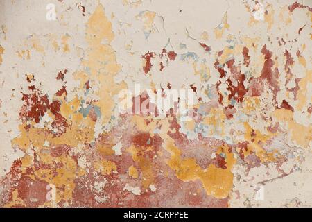 Alte schuppige abgebrochene Wand mit Kratzern und Schichten von Farbe abblättert als Alterungsprozess des vernachlässigten Hauses Ruinenfassade Stockfoto