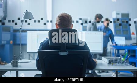 Männlicher Industrieingenieur, der Probleme löst, arbeitet an einem Personal Computer, zwei Bildschirme zeigt CAD-Software mit 3D-Prototyp der Null-Emissionen Stockfoto