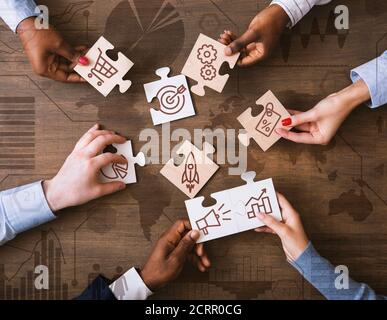 Kreative Collage Mit Geschäftsleuten Halten Puzzle-Stücke Mit Marketing Strategiesymbole Stockfoto