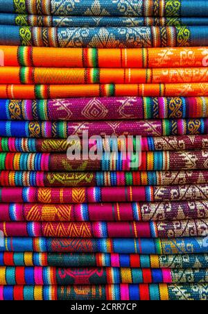 Ein Stapel von bunten traditionellen Textilien in den Anden sonntagsmarkt in Otavalo, nördlich von Quito, Ecuador. Stockfoto