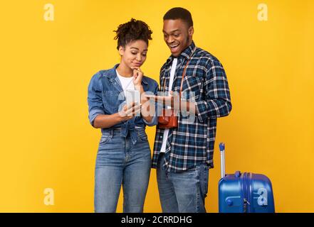 Afrikanisches Touristenpaar Mit Smartphone Wahl Trip Destination, Studio Shot Stockfoto