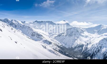 Blick von Kasprowy Wierch auf Kiefernwald mit Winterüberzug im Tal. Schneebedeckte Berggipfel der Tatra, Bukowina Tatrzanska, Polen Stockfoto