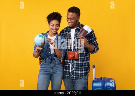 Afrikanische Touristen Holding Globe Und Tickets Auswahl Ziel In Studio Stockfoto