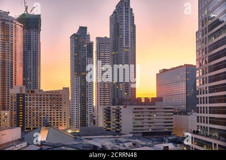 Manila, Philippinen - 01. Feb 2020: Abendansicht der Stadt Makati. Die Wolkenkratzer gegen den hellen Sonnenuntergang. Stockfoto