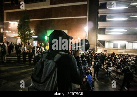 Portland, Usa. September 2020. Ein Protestler benutzt ein Megatelefon, um die Gruppe der Demonstranten durch einen marsch in der Innenstadt von Portland zu führen.für die zweite Nacht, seit die Luftverschmutzung durch die Waldbrände in Oregon in Portland gelöscht wurde, Demonstranten haben auf die Straße gegangen, um die Protestbewegung fortzusetzen, die nach der Ermordung von George Floyd begann. Kredit: SOPA Images Limited/Alamy Live Nachrichten Stockfoto