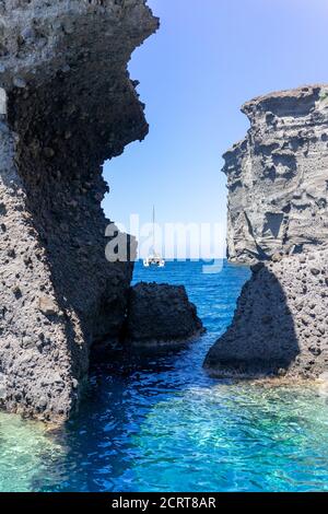 Katamaran auf dem blauen Meer zwischen Felsformation. Akrotiri, Santorini, Kykladen, Griechenland. Stockfoto