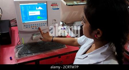 DISTRIKT KATNI, INDIEN - 27. SEPTEMBER 2019: Eine indische Labortechnikerin drückt Taste am Monitor im Pathologielabor in der städtischen Krankenhausabteilung. Stockfoto