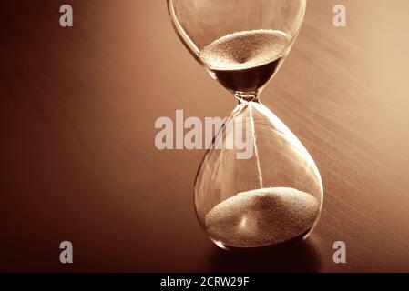 Zeit Vergangenheit Konzept mit Sanduhr. Sand, der durch die Glühbirnen läuft. Stockfoto