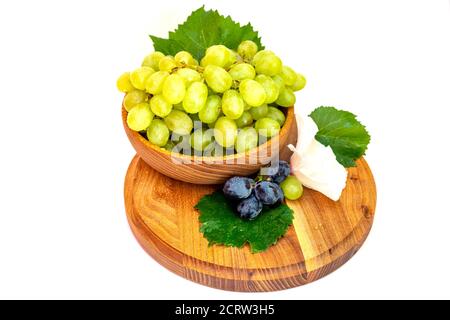 Trauben und Hibiskusblüten auf einem Holzbrett. Weißer Hintergrund. Stockfoto