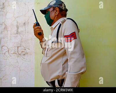 DISTRIKT KATNI, INDIEN - 21. MAI 2020: Ein indischer Polizist, der während der Dienstzeit mit einem drahtlosen Walkie-Talkie spricht und Gesichtsmast für Corona-Virus trägt Stockfoto