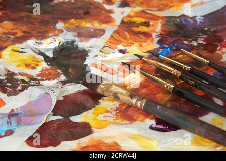 Verschiedene Größen von Pinsel und Acrylfarben auf Papier Palette Stockfoto