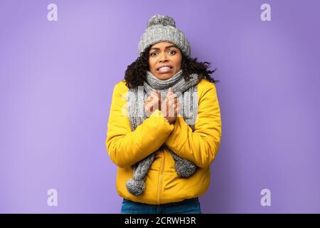 Unglücklich African Lady Einfrieren Trägt Winterkleidung Über Lila Hintergrund Stockfoto