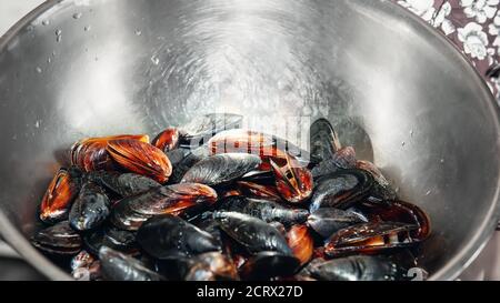 Frische Muscheln in einer Metallschüssel. Vorbereitung für einen Outdoor-Meeresfrüchte-Grill. Picknick von gesunden Lebensmitteln, Muscheln in Muscheln. Selektiver Fokus. Viel Muschel Stockfoto