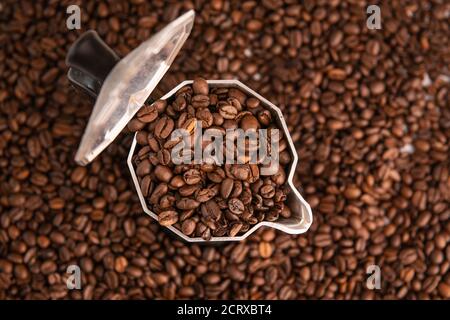 Kaffeebohnen in Mokka-Topf auf Kaffeebohnen Hintergrund Stockfoto