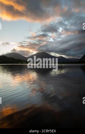 Atemberaubendes Landschaftsbild bei Sonnenaufgang mit Blick über Loweswater im See Bezirk in Richtung Low Fell und Grasmere mit bunten Himmel brechen Auf dem Berg Stockfoto
