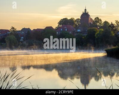 Nach Sonnenaufgang erheben sich Nebelschwaden über dem See Stockfoto