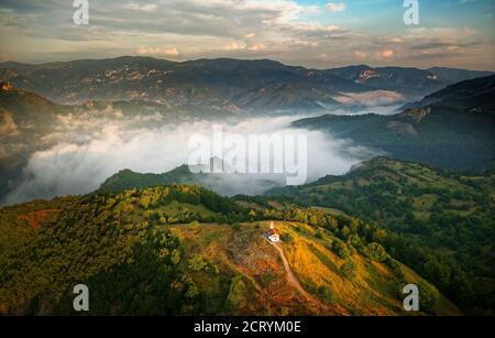 Landschaft aus den Rhodopen in Bulgarien bei Sonnenuntergang oder Sonnenaufgang. Kleine Kapelle und Kloster in der Nähe von Borovo, Rhodopen. Stockfoto