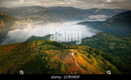 Landschaft aus den Rhodopen in Bulgarien bei Sonnenuntergang oder Sonnenaufgang. Kleine Kapelle und Kloster in der Nähe von Borovo, Rhodopen. Stockfoto